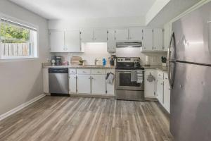 a kitchen with white cabinets and a stainless steel refrigerator at Townhomes Near the Bay - #8 in Grand Bay