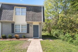 a house with a blue door in the yard at Townhomes Near the Bay - #8 in Grand Bay