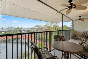 a balcony with a table and chairs and a ceiling fan at Scenic Resort Views From This 3rd Floor Deluxe Condo in Naples