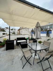 patio ze stołem, krzesłami i parasolem w obiekcie Gabriele-Apartment w mieście Gallipoli +23 zdjęcia