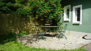 a picnic table and chairs in front of a tree at Ferienwohnung Hörlkofen in Wörth
