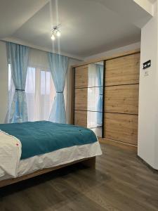a bedroom with a large bed and blue curtains at Vila Dor de Munti in Râşnov