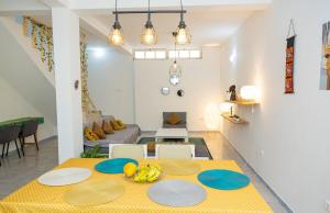 a living room with a yellow table and a couch at Marel Bliss Apartments T3-Luisa in Mindelo