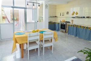 a kitchen with a table with a yellow table cloth at Marel Bliss Apartments T3-Luisa in Mindelo