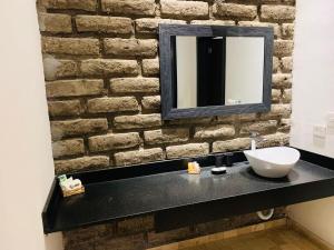 bagno con lavandino bianco e parete in mattoni di Hotel Boutique Embrujo Murmullo a Parras de la Fuente