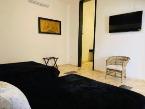 una camera con letto, sedia e TV a schermo piatto di Hotel Boutique Embrujo Murmullo a Parras de la Fuente