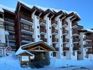 a large apartment building with snow on the ground at Appartement 2 pièces au pied des pistes à Plagne Villages, balcon nord, casiers à skis, 6 pers. - FR-1-351-59 in La Plagne