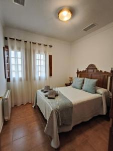 una camera con un grande letto e due finestre di Apartamentos Cortijo los Jacintos a Ronda Altre 39 foto