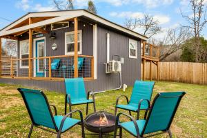 a group of chairs and a fire pit in front of a tiny house at Hunka Hunka Cabin in New Braunfels +14 photos