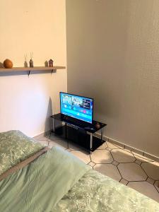 un televisor sentado en una mesa en una habitación en Comfort Bedroom, en Cergy