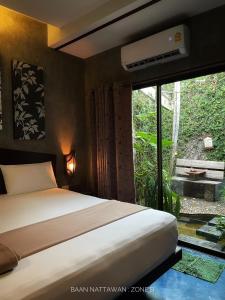 una camera da letto con un letto e una grande finestra di บ้านณัฐวรรณ หัวหิน Zone B - Baan Nattawan Huahin Zone B a Hua Hin