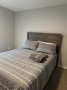 un lit avec une couverture grise et des oreillers dessus dans l'établissement The red cottage of Erlanger, à Lexington