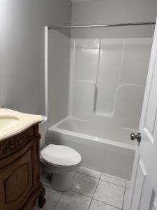 une salle de bain blanche avec toilettes et baignoire dans l'établissement The red cottage of Erlanger, à Lexington
