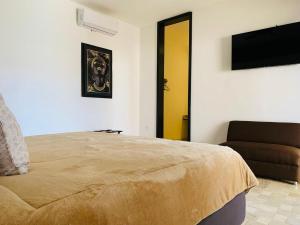a bedroom with a bed and a couch and a flat screen tv at Hotel Boutique Embrujo Deseo in Parras de la Fuente