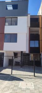 a building with a fence in front of it at Roca Luminosa, a cozy 2 bedroom apartment in Riobamba