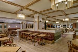 ヒューストンにあるThe Westin Oaks Houston at the Galleriaのテーブルと椅子とバーのあるレストラン