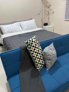 - un canapé bleu avec deux oreillers dans la chambre dans l'établissement studio flat at 101 Newport Boulevard, à Manille