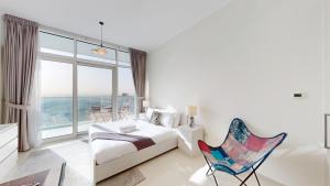 Dubai MarinaCarson C - Spacious Studio with Golf Course Views的一间卧室，里面有一张床、一把椅子和一扇窗户 更多12张照片