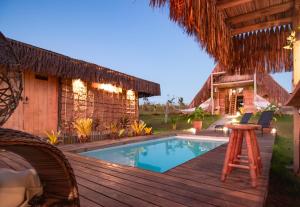 a resort with a swimming pool and a wooden deck at Cabana Serena in Corumbau