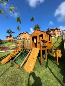 drewniany plac zabaw z domkiem zabaw na trawie w obiekcie Apto 102 T10 Eco Resort com 2 qts w mieście Tamandaré