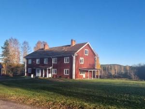 a large red house on a grass field at Woxy Lilaloppan - privacy, space and nature in Voxnabruk
