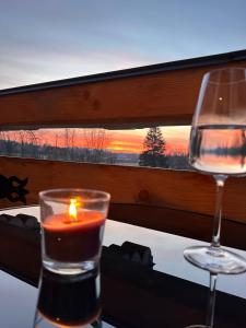 a candle and a wine glass on a table with a window at Chochołowski Zakątek in Chochołów