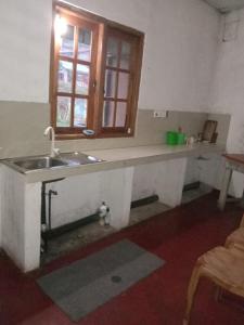a kitchen with a sink and a window at Rimadi Lake Guest Inn in Eravur