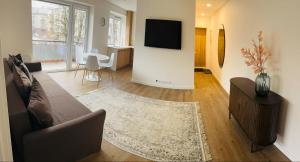 a living room with a couch and a television on a wall at STAR apartamentai in Panevėžys