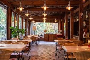 a dining room with tables and chairs and windows at Młyn Klekotki Spa Resort in Klekotki