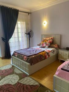 a bedroom with a large bed and a fan at Lovely 3-Bedroom Rental Unit with Pool in Sheikh Zayed