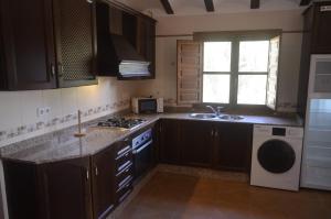 una cocina con fregadero y estufa horno superior en Los Cuchillos, en Bullas