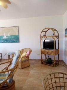 ein Wohnzimmer mit einem TV, Stühlen und einem Tisch in der Unterkunft Apto en Porlamar - Nueva esparta, a 5 min de playa Concorde in Porlamar