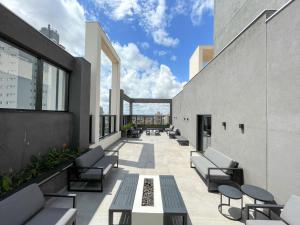 a patio with couches and tables on a building at Lindo Flat Planejado com Vista Para Cidade in Campo Grande