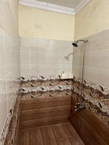 y baño con ducha y suelo de madera. en Enjoy Holidays as its your own place, en Lahore