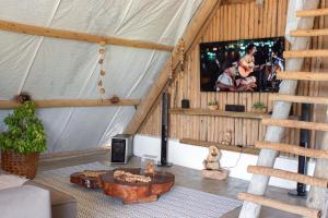 a living room with a tv in a tent at Cabana Serena in Corumbau