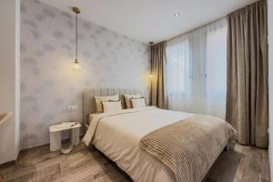 Un dormitorio con una cama grande y una ventana. en Novus Homes Barcelona Plaza España, en Barcelona