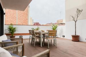 Un comedor con mesa y sillas y una ventana. en Novus Homes Barcelona Plaza España, en Barcelona