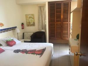 a bedroom with a bed and a chair in a room at Апартаменты 303 - Studio in Funchal +36 photos