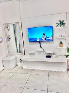 a living room with a tv on a white wall at C-junction studio apartment in Windhoek