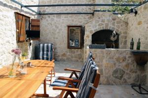 a dining room with a table and a stone fireplace at Mountain Stone Villa with pool in Stanići