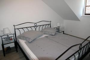 a bed with two pillows on it in a room at Mountain Stone Villa with pool in Stanići