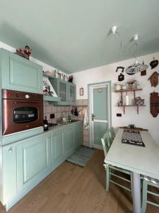 a kitchen with mint green cabinets and a table with a tableablish at Casa Lucrezia - Valbruna in Valbruna
