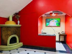 a red room with a fireplace and a tv at Departamento Familiar en el Centro de Baños in Baños