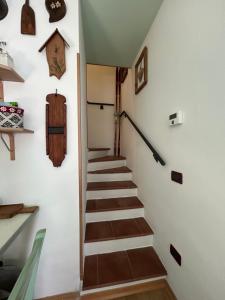 a stairway in a home with wooden steps and wall arts at Casa Lucrezia - Valbruna in Valbruna