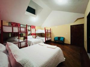 a room with three beds and two bunk beds at Departamento Familiar en el Centro de Baños in Baños