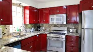 a red kitchen with stainless steel appliances and red cabinets at Tijuana Beach View & Patio in Tijuana