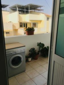 a washing machine in a room with a building at Sweet Spot Palmarejo in Praia