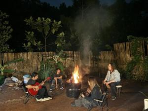 a group of people sitting around a fire at Kawayan Farmstead in Antipolo