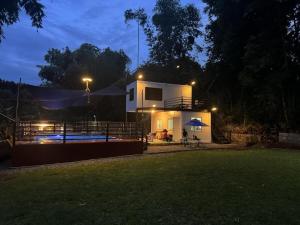 a house with a pool in the yard at night at Kawayan Farmstead in Antipolo