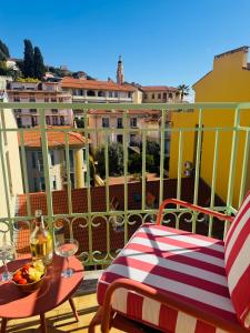 a balcony with a table and chairs on a balcony at Hôtel Gabriel in Menton